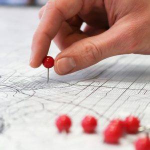 Close up photo of a hand putting pins in a map