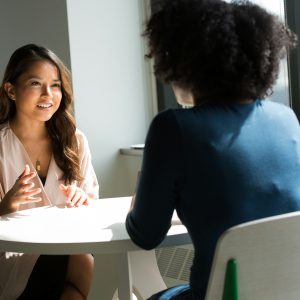 Two professional women having an informal conversation.