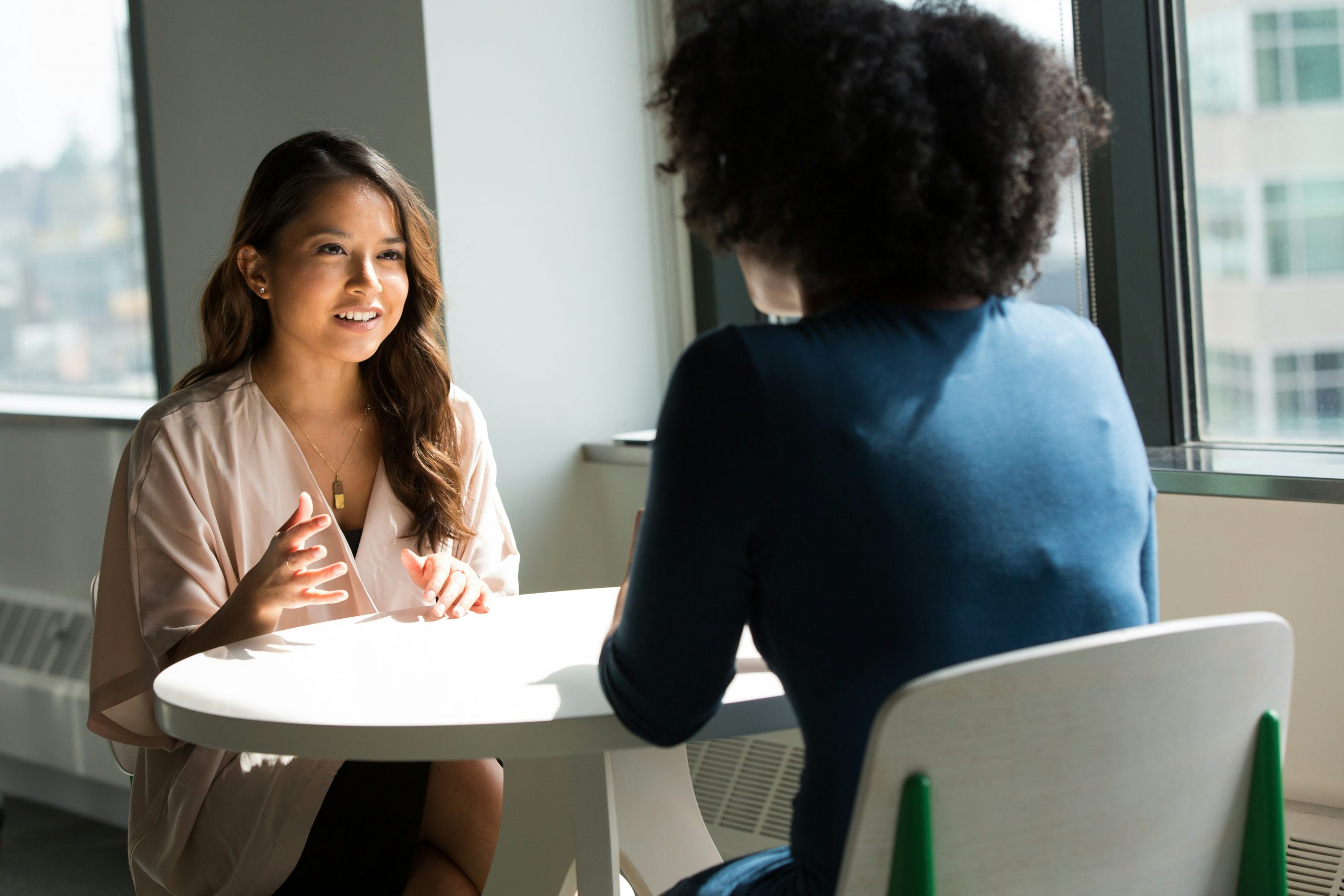 Two professional women having an informal conversation.