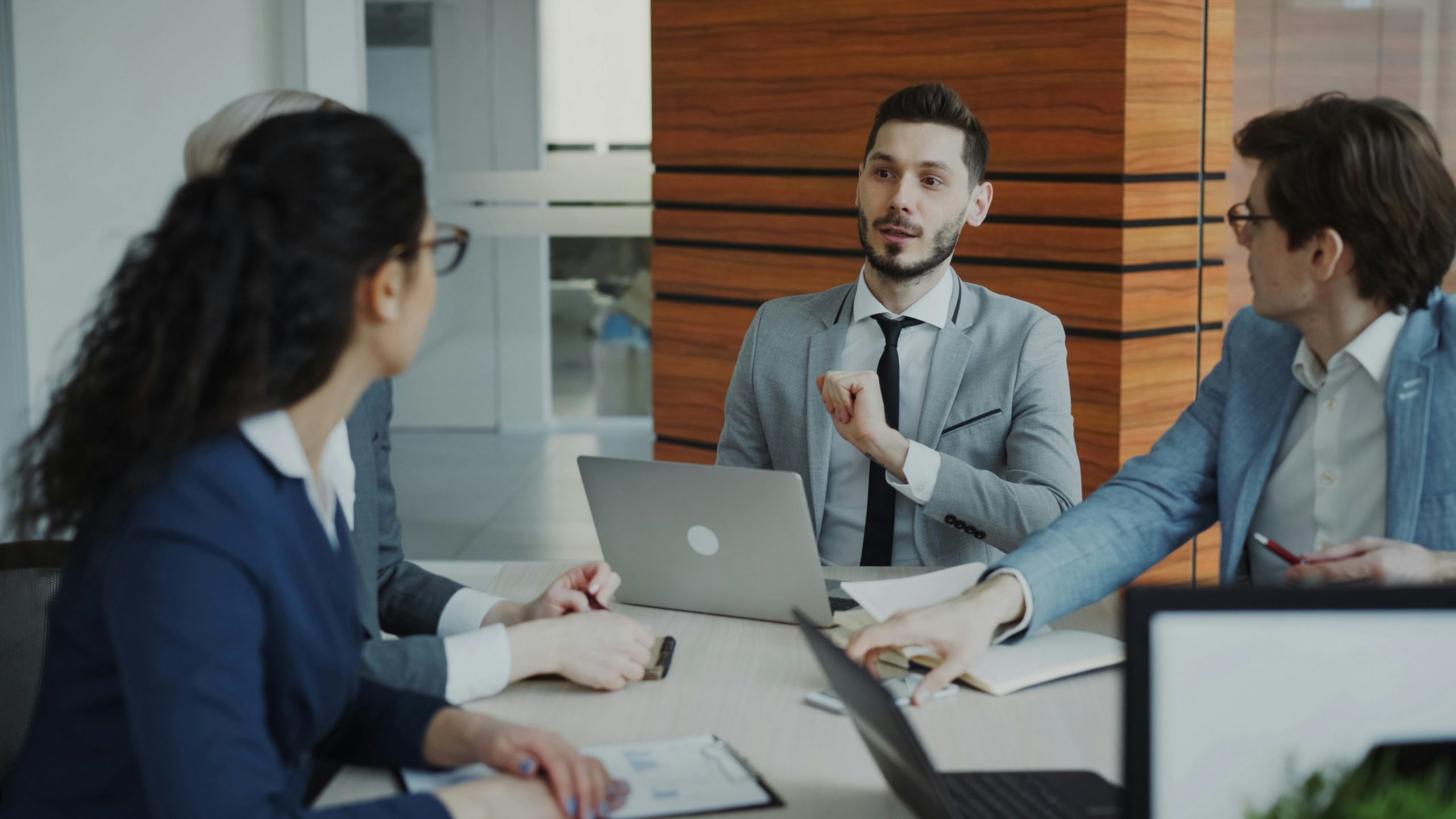 Top view of group of business people in suits discussing financial graphs in lobby of business center