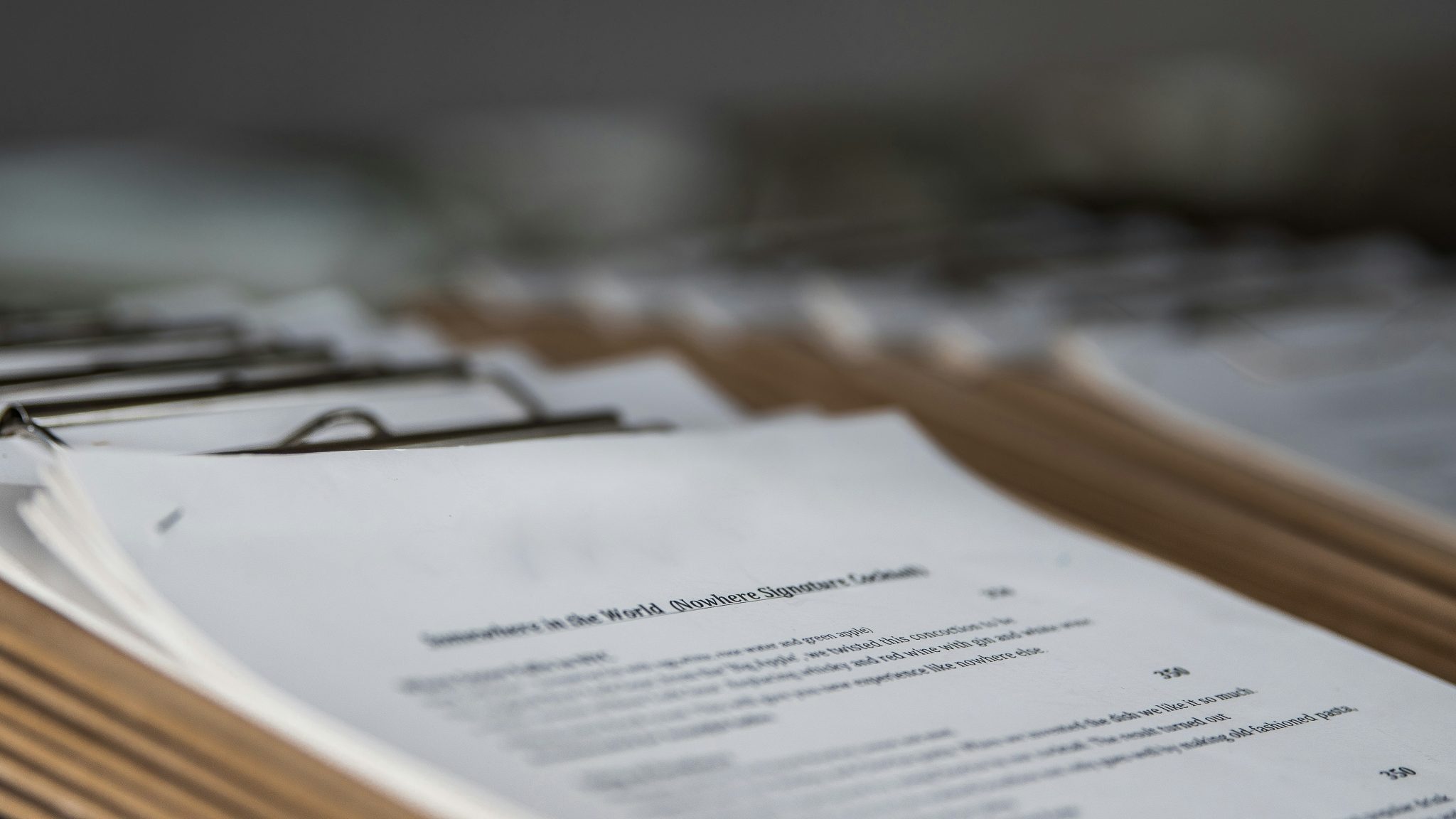 Pile of legal documents on a desk, in clipboards.